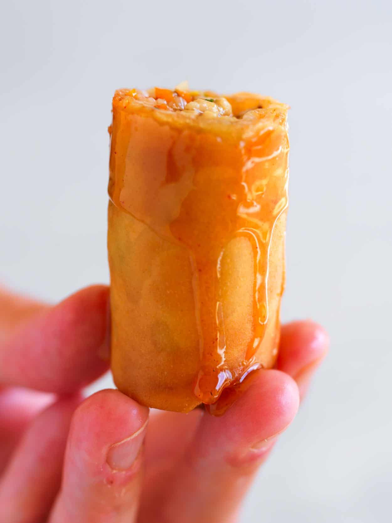 A spring roll dipped into homemade spring roll sauce