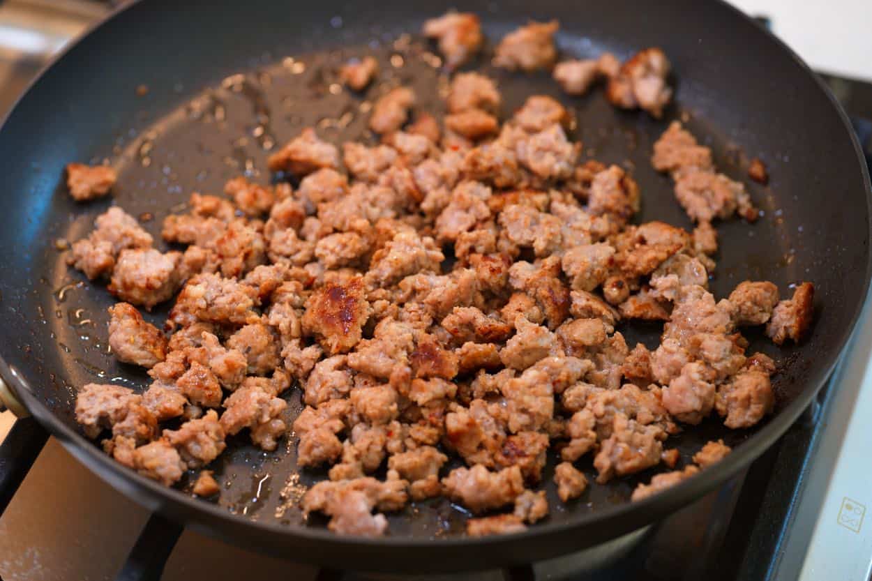 Browning sausage in a skillet for the tater tot egg bake.